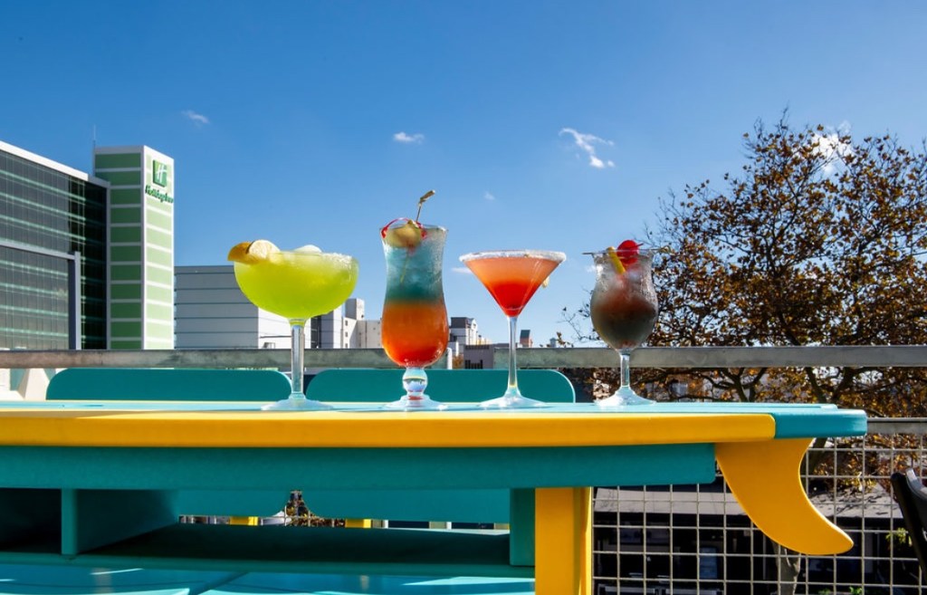 Colorful cocktails on a surfboard patio table at Lucy's Sky Bar in Virginia Beach